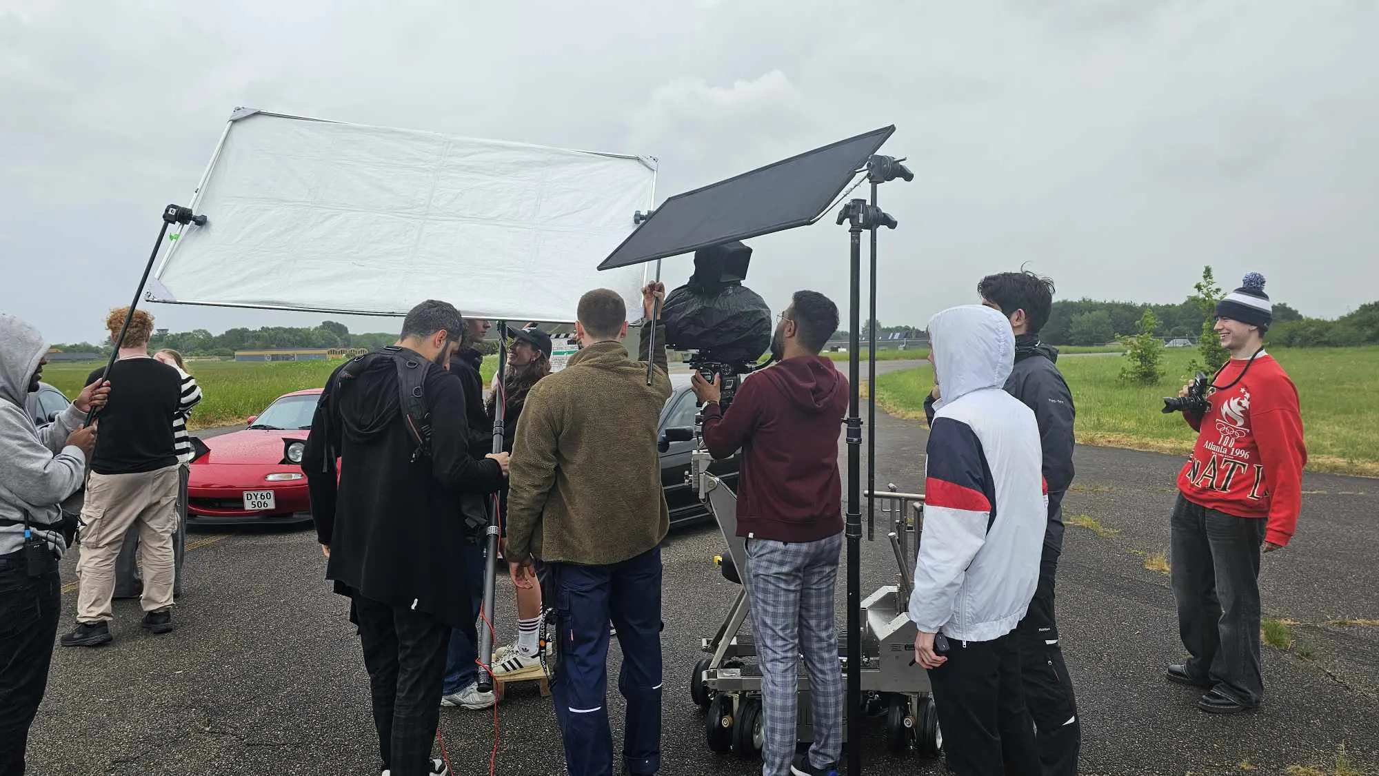 The Minehubs Studios crew on set, filming with a camera dolly on an airfield